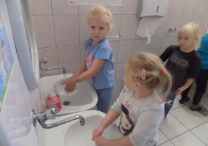 Hania i Asia ćwiczą prawidłowe mycie rąk przy umywalce.